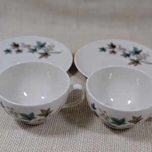 Mid‑century Syracuse China Woodbine 2 cup and saucers sets with the aqua and brown floral motif on a bright white glaze.