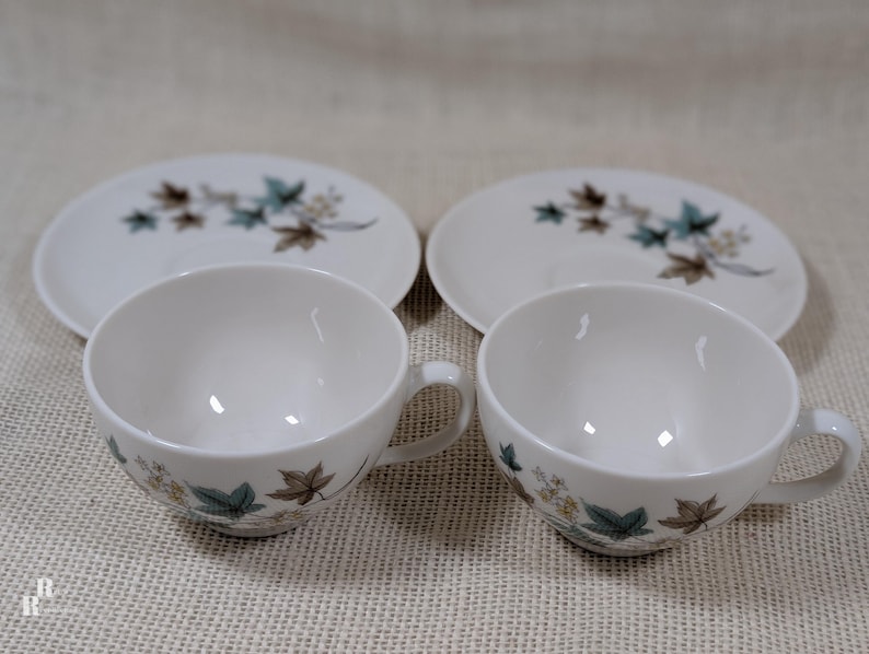 Mid‑century Syracuse China Woodbine 2 cup and saucers sets with the aqua and brown floral motif on a bright white glaze.