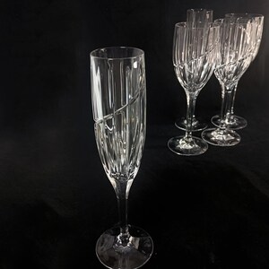 Vintage Mikasa Uptown clear heavy cut crytal stemware. This 5 piece set consists of three 9 inch water goblets and two 9 1/2 inch fluted champagne glasses. The bowls are vertically cut and polished from the rim to the stem and one horizontal spiral around the bowl. The tall slender stems are six-sided and curver gracerully into thesix-segmented foot.
