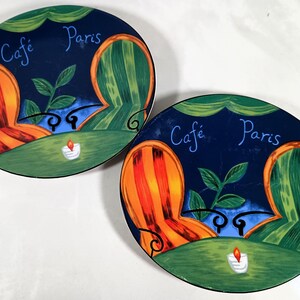 Sango furio French Cafe oval salad platters.  Heavy  ceramic plates with a green, orange, and yellow striped chair design. The plates feature the text "Cafe Paris" in a blue script font.
