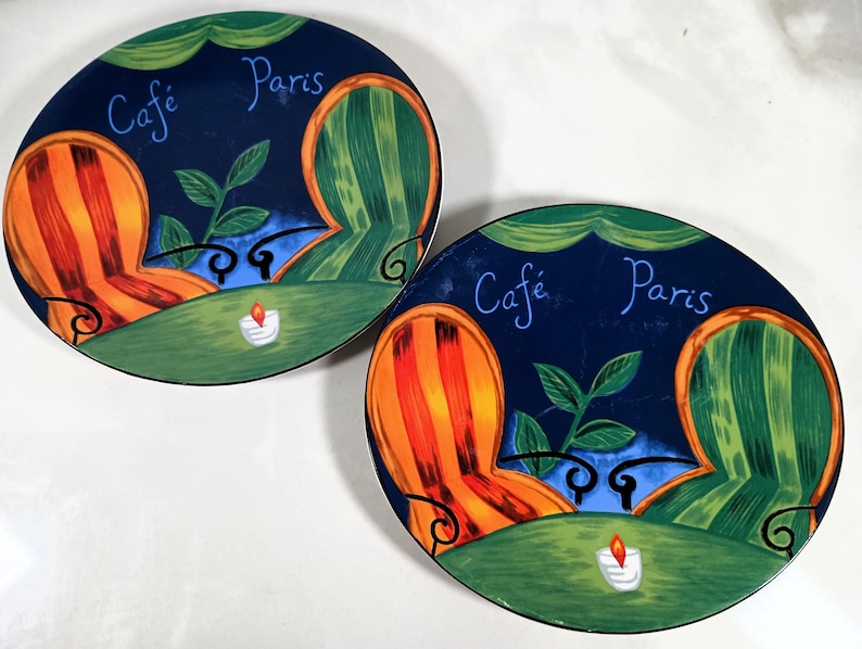 Sango furio French Cafe oval salad platters.  Heavy  ceramic plates with a green, orange, and yellow striped chair design. The plates feature the text "Cafe Paris" in a blue script font.