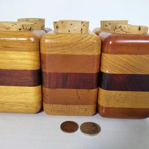 Mid Century Turned Stacked Layered Wood Spice Containers with Cork Stoppers. Set of 6 wooden spice jars  ade of Layers of various varieties of dark and light colored wood stacked together, turned, and finished to warm rich layers of natural wood.