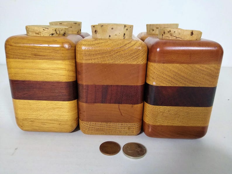 Mid Century Turned Stacked Layered Wood Spice Containers with Cork Stoppers. Set of 6 wooden spice jars  ade of Layers of various varieties of dark and light colored wood stacked together, turned, and finished to warm rich layers of natural wood.