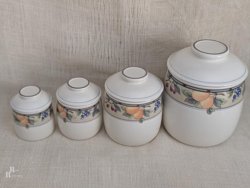 Mikasa Garden Harvest CAC29 stoneware canister set with fruit and leaf border on cream glaze.