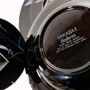 K&ouml;nnte beinhalten: Schwarzer und wei&szlig;er Teller mit floralem Design und dem Text "MIKASA Galleria FK701 OPUS-BLACK OVEN TO TABLE TO DISHWASHER SAFE FOR MICROWAVE OVEN JAPAN" auf der Unterseite.