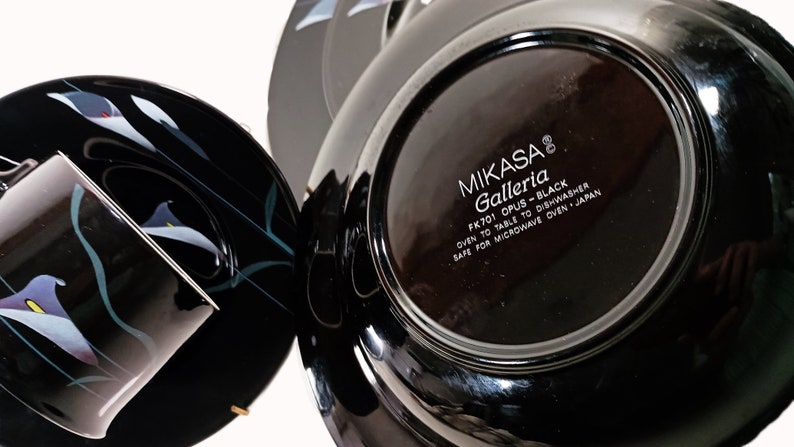 K&ouml;nnte beinhalten: Schwarzer und wei&szlig;er Teller mit floralem Design und dem Text "MIKASA Galleria FK701 OPUS-BLACK OVEN TO TABLE TO DISHWASHER SAFE FOR MICROWAVE OVEN JAPAN" auf der Unterseite.