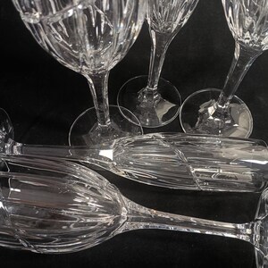 Vintage Mikasa Uptown clear heavy cut crytal stemware. This 5 piece set consists of three 9 inch water goblets and two 9 1/2 inch fluted champagne glasses. The bowls are vertically cut and polished from the rim to the stem and one horizontal spiral around the bowl. The tall slender stems are six-sided and curver gracerully into thesix-segmented foot.