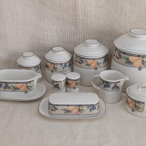 Mikasa Garden Harvest CAC29 stoneware serving pieces and canister set with fruit and leaf border on cream glaze.
