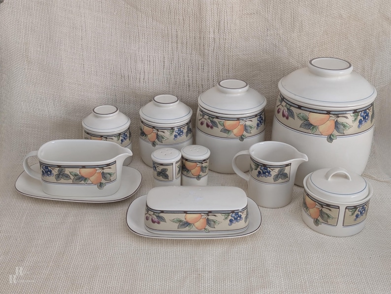 Mikasa Garden Harvest CAC29 stoneware serving pieces and canister set with fruit and leaf border on cream glaze.