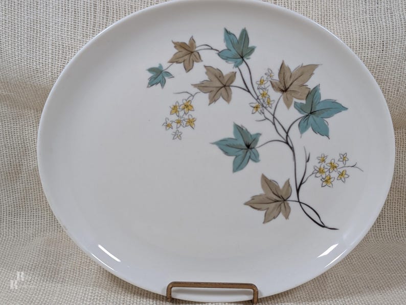 Mid‑century Syracuse China Woodbine pieces including an oval platter with the aqua and brown floral motif on a bright white glaze.