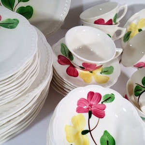 May include: A set of vintage floral china dinnerware featuring a pink, yellow, and green floral pattern. The set includes plates, bowls, and teacups.