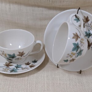 Mid‑century Syracuse China Woodbine 2 cup and saucers sets with the aqua and brown floral motif on a bright white glaze.