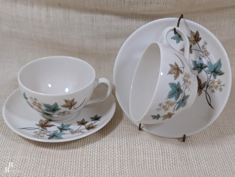 Mid‑century Syracuse China Woodbine 2 cup and saucers sets with the aqua and brown floral motif on a bright white glaze.