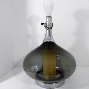 Mid Century Modern Minimalist Blenko Art Glass Table Lamp. Hand blown smoke glass garlic shape body, chrome finish neck and base. Fiberglass light diffuser inside glass body for mood light.