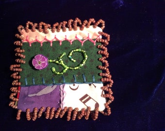 Square pin brooch with flower.