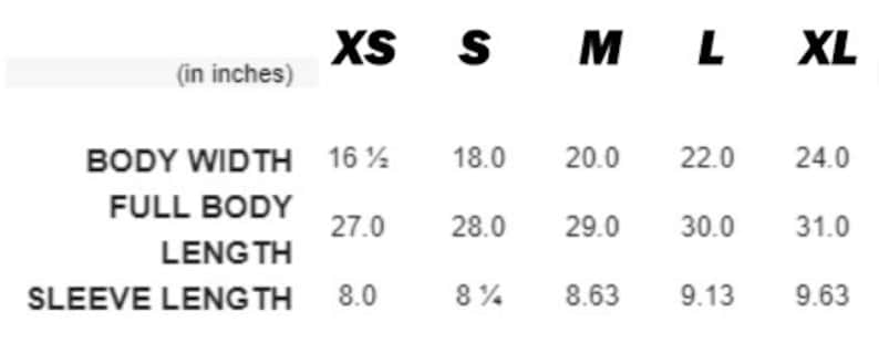May include: A size chart in inches for apparel, featuring columns for XS, S, M, L, and XL. Rows list Body Width, Full Body Length, and Sleeve Length with corresponding numerical values for each size, presented in black text on a white background.