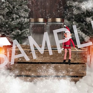 May include: Two clear glass jars with gold lids sit on a wooden crate with a Christmas elf doll sitting on top. The jars are empty and the elf is wearing a red and white striped outfit. The scene is set in a snowy winter setting with a white background.