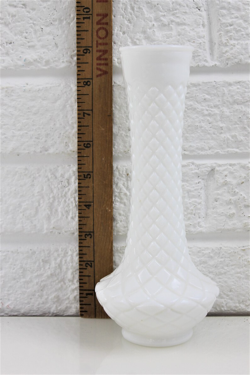 Puede incluir: Un jarr&oacute;n blanco de vidrio de leche con un patr&oacute;n de diamante. El jarr&oacute;n mide aproximadamente 18 cm de alto.
