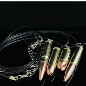 K&ouml;nnte beinhalten: Ein Satz von vier kugelf&ouml;rmigen Anh&auml;ngern an schwarzen Lederb&auml;ndern. Die Anh&auml;nger sind aus Messing und haben eine goldene Oberfl&auml;che. Die B&auml;nder sind mit einer silbernen Kette zusammengebunden.