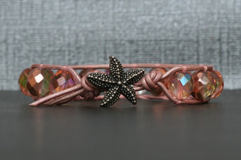 May include: A pink leather bracelet with iridescent pink glass beads and a silver starfish charm.