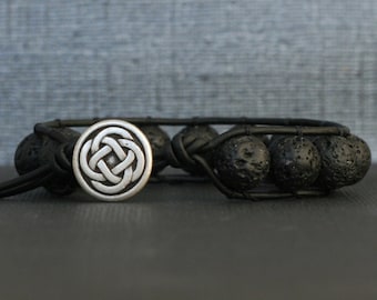 May include: Black lava rock beaded bracelet with a silver Celtic knot charm.