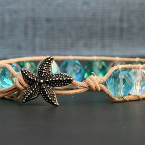 May include: A brown leather bracelet with blue and clear glass beads and a silver starfish charm.