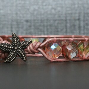 May include: A pink leather bracelet with iridescent glass beads and a silver starfish charm.