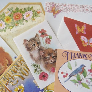 May include: A collection of vintage-style greeting cards and envelopes. Designs include floral arrangements, kittens, butterflies, and a bluebird. Several cards feature the words "THANK YOU" in elegant script. The color palette includes soft pastels and earth tones.