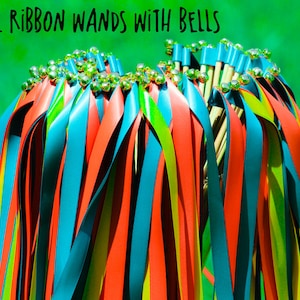 May include: A bunch of colorful ribbon wands with bells on the ends. The ribbons are red, blue, and yellow. The wands are made of wood and have a silver bell on the end of each ribbon.