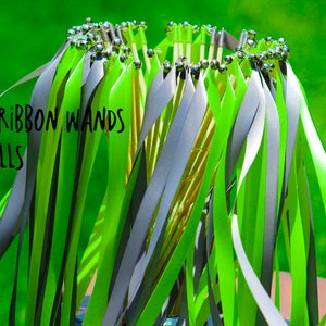 May include: A bunch of single ribbon wands with bells. The wands have green and gray ribbons attached to a stick with silver bells at the top.