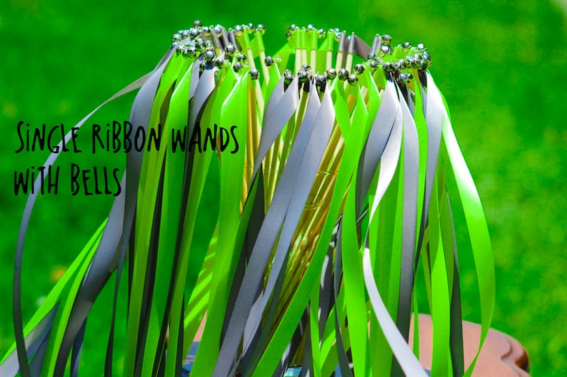 May include: A bunch of single ribbon wands with bells. The wands have green and gray ribbons attached to a stick with silver bells at the top.