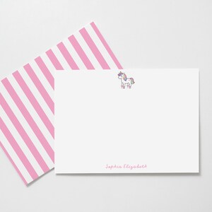 Peut inclure: Ensemble de papeterie blanc comprenant une enveloppe à rayures roses et blanches et une carte assortie. La carte présente une illustration de licorne et le nom "Sophia Elizabeth" en écriture rose. Pour correspondance personnelle.