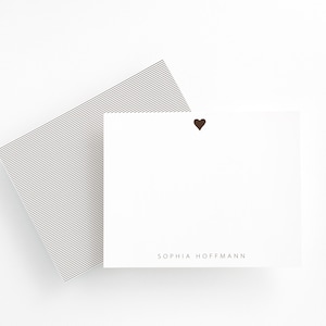 May include: White card with a small brown heart in the top right corner and the text "SOPHIA HOFFMANN" at the bottom.