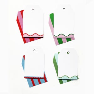 May include: Four white gift tags with scalloped edges and colorful striped accents. Each tag has a hole at the top for stringing. The striped accents are red, pink, blue, and green.
