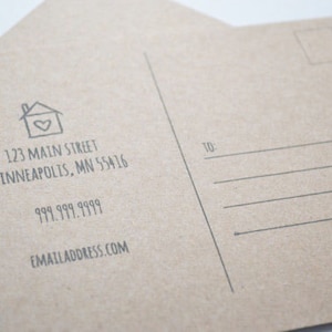 May include: A brown postcard with a house icon and the text "123 Main Street, Minneapolis, MN 55416, 999.999.9999, emailaddress.com" printed on the front. The back of the postcard has a space for an address and a stamp.