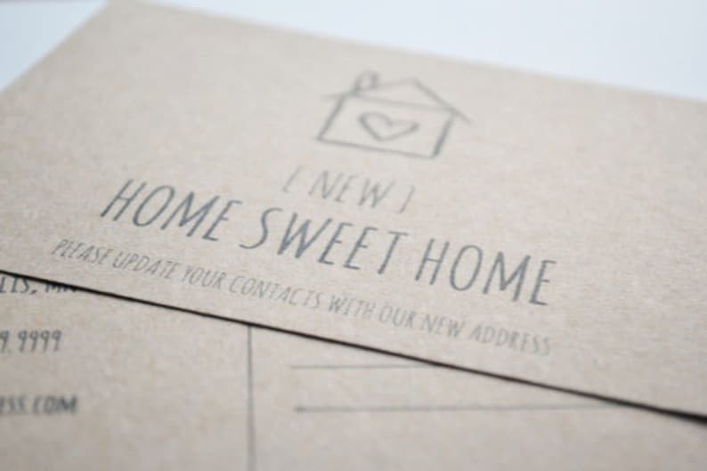 May include: A brown card with the text "[NEW] HOME SWEET HOME" and a simple house drawing with a heart inside. The text below the house says "PLEASE UPDATE YOUR CONTACTS WITH OUR NEW ADDRESS".