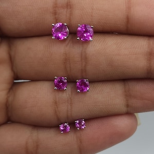 May include: Three pairs of pink gemstone earrings with silver settings. The earrings are arranged in order of size, with the largest pair at the top and the smallest pair at the bottom.