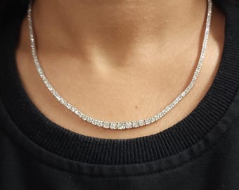 May include: A silver chain necklace with small, round, clear stones set in a continuous line.
