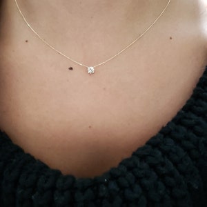 Puede incluir: Un delicado collar de cadena de oro con un solo colgante de diamante redondo y transparente. El collar mide 40,64 cm de largo y el diamante 0,40 quilates.