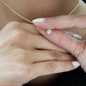 Puede incluir: Un delicado collar de cadena de oro con un peque&ntilde;o colgante redondo de diamante. El diamante es de 0,40 quilates.