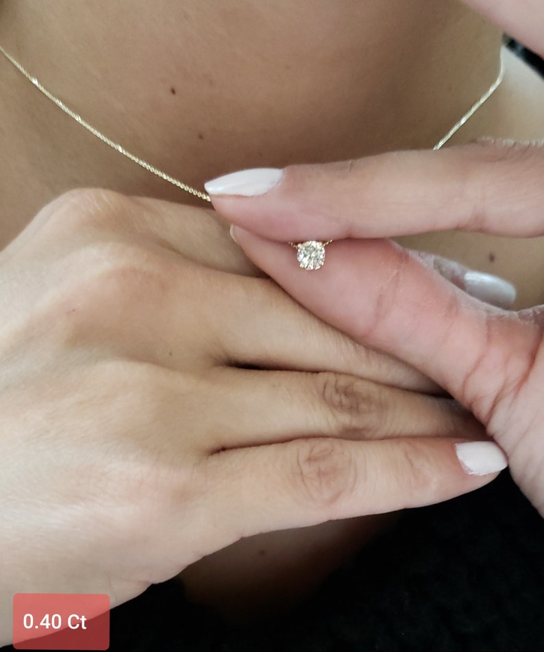 Puede incluir: Un delicado collar de cadena de oro con un peque&ntilde;o colgante redondo de diamante. El diamante es de 0,40 quilates.