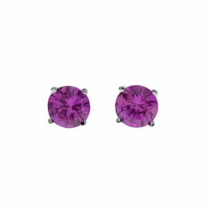 May include: A pair of silver stud earrings with round, purple gemstones.