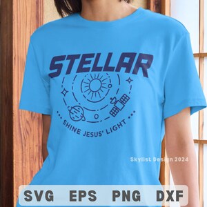 May include: A light blue t-shirt with the word "STELLAR" in dark blue block letters. Below the word is a dark blue graphic of the sun, planets, and a satellite. The text "SHINE JESUS' LIGHT" is below the graphic.