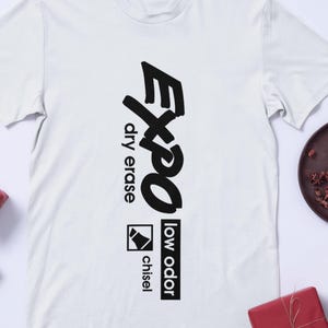 May include: White t-shirt with a black "Expo" logo, "dry erase", "low odor", and "chisel" text.