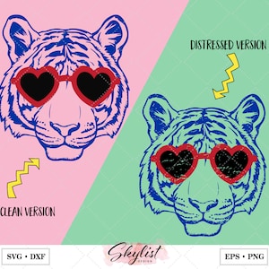 May include: A graphic design featuring a tiger's face wearing red heart-shaped sunglasses. The design is in blue and black, with a pink and green background. Text includes "CLEAN VERSION" and "DISTRESSED VERSION".