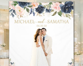 May include: A white backdrop with a floral design in shades of pink and blue. The text "MICHAEL and SAMATHA 06.20.20" is printed in gold. A photo of a bride and groom is in the center of the backdrop.