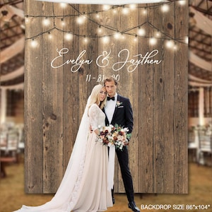 May include: Rustic wooden backdrop with string lights, featuring a couple in wedding attire. The backdrop has the text "Evelyn & Jaythen 11-31-20" written in white cursive font. The backdrop size is 86"x104".