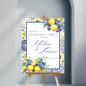 May include: Welcome to the Engagement Party sign with a blue and yellow tile pattern and lemons and blueberries. The sign says "Welcome to the Engagement Party celebrating Melvin & Leanne July 16, 2025".