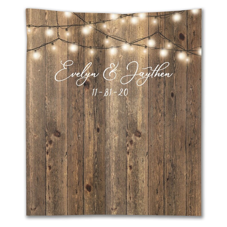 May include: Rustic wood backdrop with string lights and the text "Evelyn & Jaythen 11-31-20" in white.