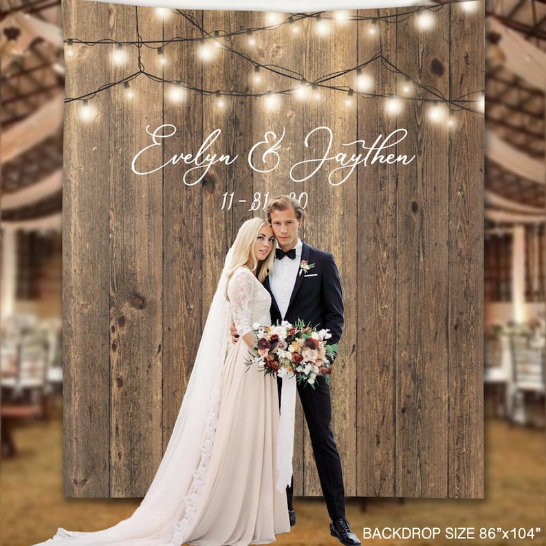 May include: Rustic wooden backdrop with string lights, featuring a couple in wedding attire. The backdrop has the text "Evelyn & Jaythen 11-31-20" written in white cursive font. The backdrop size is 86"x104".